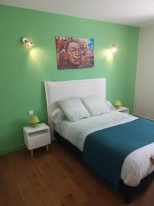 马里尼亚讷Escale villa的卧室配有一张床,墙上挂有绘画作品