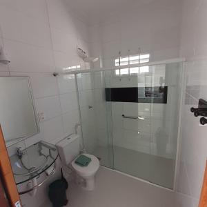 弗洛里亚诺波利斯Suíte confortável的带淋浴、卫生间和盥洗盆的浴室