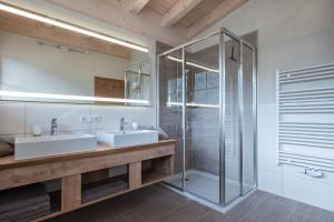 佩尔蒂绍洛森霍夫公寓的一间带两个水槽和玻璃淋浴间的浴室