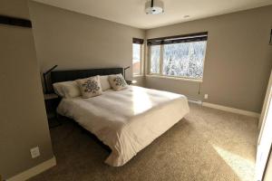 太阳峰Zola Retreat- RARE Luxury Ski in/out *Hot tub, BBQ, Double heated garage*的一间卧室设有一张大床和一个窗户。