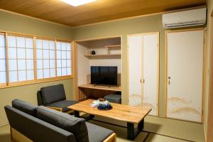 高松瀬戸風月的客厅配有桌椅和电视。