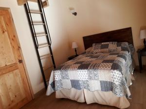 科万Estancia del Monje的一间卧室设有一张床和木梯