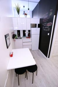 扎达尔The Hostel的厨房配有白色桌子和黑白冰箱。
