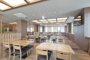 栗东Hotel Route Inn Kusatsu Ritto -Ritto Inter Kokudo 1 gou-的用餐室配有木桌和椅子