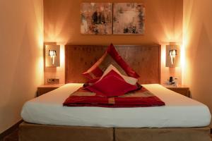 奥厄恩格尔布拉尔酒店的一间卧室配有一张带红色枕头的大床