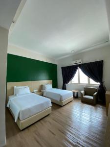 峇株巴辖峇株巴辖峰会西格尼酒店的一间卧室设有两张床和绿色的墙壁