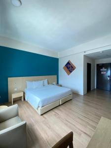 峇株巴辖峇株巴辖峰会西格尼酒店的卧室配有一张白色大床和蓝色的墙壁