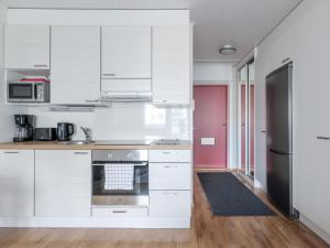 约恩苏Kotimaailma Apartments Joensuu - Koulukatu 21的厨房配有白色橱柜和不锈钢冰箱