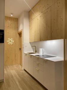 扎科帕内Apartament Skiturowy Jagiellonska Residence的厨房配有白色的柜台和木制橱柜。