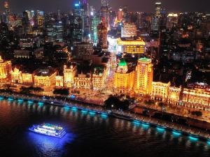 上海上海和平饭店的夜间与城市一起在水中航行的船只