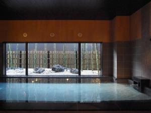 二本松Hotel Route-Inn Nihonmatsu的一座带大窗户的建筑中的游泳池