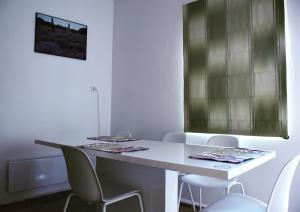 鲍洛托瑙考利Pellegrini Apartman的白色的客房配有白色的桌子和椅子
