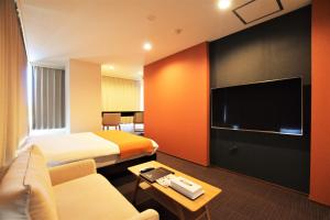 东京Randor Residence Tokyo Suites的酒店客房设有两张床和一台平面电视。