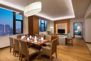 天津天津中北假日酒店的一间带桌椅的用餐室和一间客厅