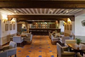 奥罗佩萨奥罗佩萨酒店的一间带桌椅的餐厅和一间酒吧