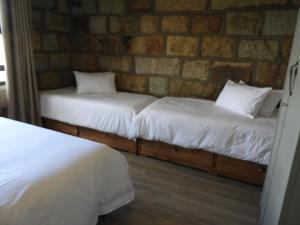 富里斯堡Oranje Guest Farm的砖墙客房的两张床