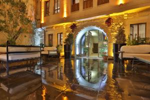 于尔居普Aja Cappadocia Cave Hotel的大厅,带拱门和椅子的建筑