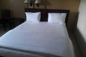 美娜多RedDoorz Brand MAN12045 RedDoorz near Megamall Manado的一张白色大床,配有白色床单和枕头
