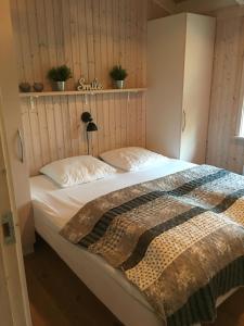 斯卡恩Nordboferie - Tranevænget 8 Hulsig的一间卧室配有一张带白色床单的大床