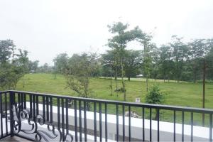玛琅RedDoorz near Araya Family Club House的享有田野和树木景致的阳台