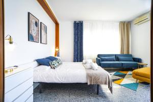 巴塞罗那巴塞罗那泳池别墅的一间卧室配有一张床和一张蓝色的沙发