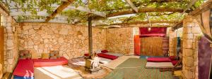 MikhmannimBack to Nature Camping & Huts的石头建筑中带几张床的房间