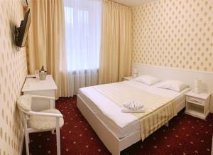 尼古拉耶夫Sergeev Hotel的卧室配有床、椅子和窗户。