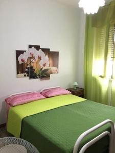 皮佐Villa Orietta的一间卧室配有带鲜花的绿色床