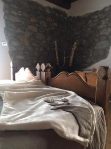 Roure Turin佩罗多克乡村民宿的一间卧室配有一张石墙床