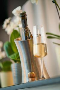 巴登-巴登赫希兰德卡斯托酒店的一瓶香槟和一张桌子上的两杯酒