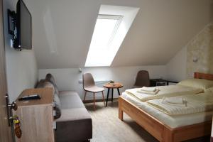 塞德莱茨Penzion Sedlecká vína的一间卧室配有一张床、一张沙发和一个窗口