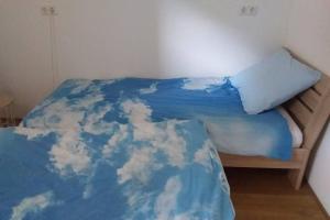 多德雷赫特Huis bij de Catalpa的一张床上,上面有蓝色的毯子,上面有云