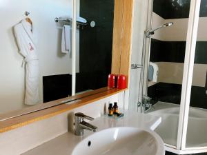 拉巴特Le Pietri Urban Hotel的一间带水槽和镜子的浴室