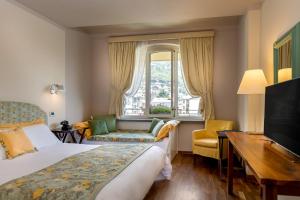 圣文森特Bijou Hotel的配有一张床、一张书桌和一扇窗户的酒店客房