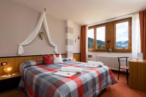 梅扎纳Animae Natura Hotel & Chalet的一间卧室配有带枕头的床