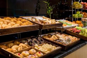 罗萨里奥罗萨里奥快捷假日酒店的面包店,托盘里放着许多不同类型的糕点