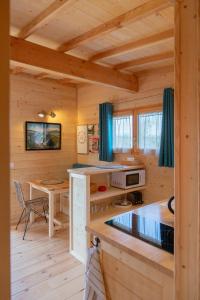 VirigninLes Lodges de la ViaRhôna / cabane-spa的小木屋设有厨房和桌子