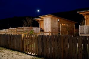 VirigninLes Lodges de la ViaRhôna / cabane-spa的夜间房子前面的木栅栏
