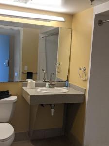 来特斯维比奇Harbor Inn的一间带水槽、卫生间和镜子的浴室