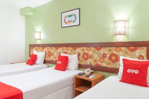 阿拉卡茹OYO Alto Da Praia Hotel, Aracaju的配有红色和白色枕头的客房内的两张床