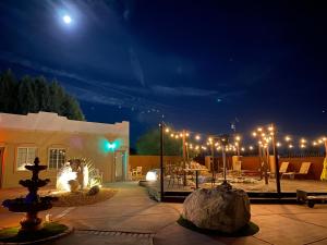 沙漠温泉MI KASA HOT SPRINGS 420,Adults Only, Clothing Optional的庭院设有喷泉,晚上有灯光