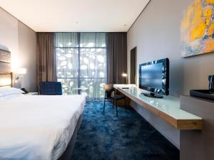 德班aha Gateway Hotel Umhlanga的酒店客房设有一张床和一张带电视的书桌。