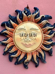 诺利La Casa di Sandra a Noli的粉红色墙上的太阳形钟