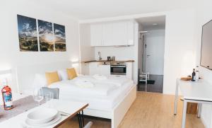 沙伊代格HEIMATEL - Ferienwohnungen的白色的客厅配有床和桌子