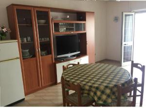 加利亚诺德尔卡波Marina Novaglie - 300m mare的一间带桌子和电视的客厅以及一间厨房。
