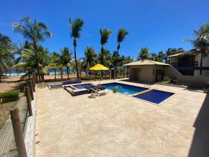 萨尔瓦多Casa Tropical pé na areia的一个带游泳池和棕榈树的度假村