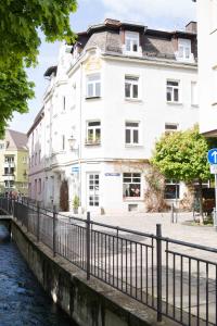 奥格斯堡Altstadt Charme的一座白色的建筑,靠近一条有桥的河流