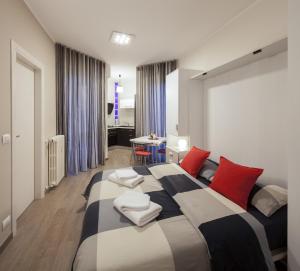 科莱尼奥Metro Apartment的一间卧室配有一张带红色和白色枕头的大床