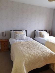 斯特罗姆内斯豪维度假屋的卧室内的两张床,配有白色床单和枕头