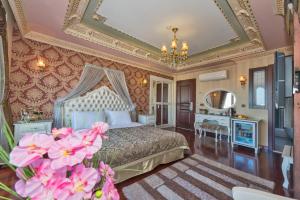 伊斯坦布尔金角湾酒店的一间卧室配有床、镜子和粉红色的鲜花